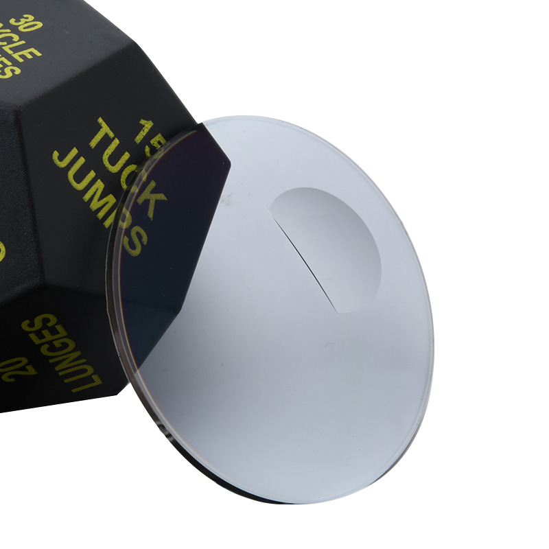 A pale LensPT lens photographed at an angle, with its straight-edged bifocal segment visible.